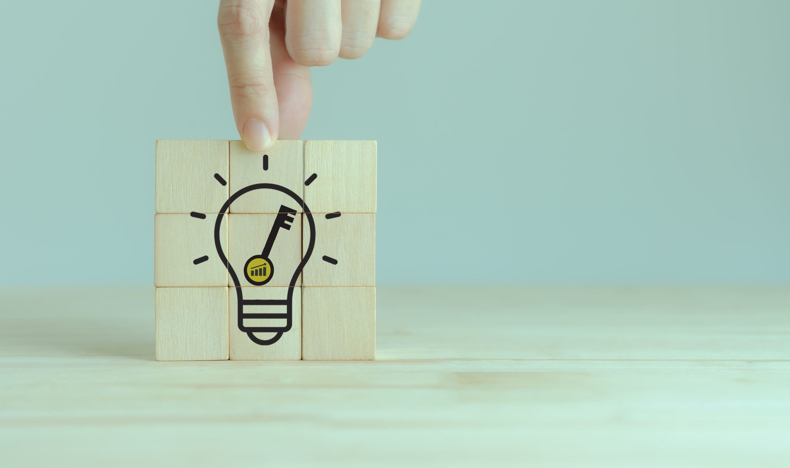 Wooden blocks stacked on so that an image of key inside a light bulb is formed